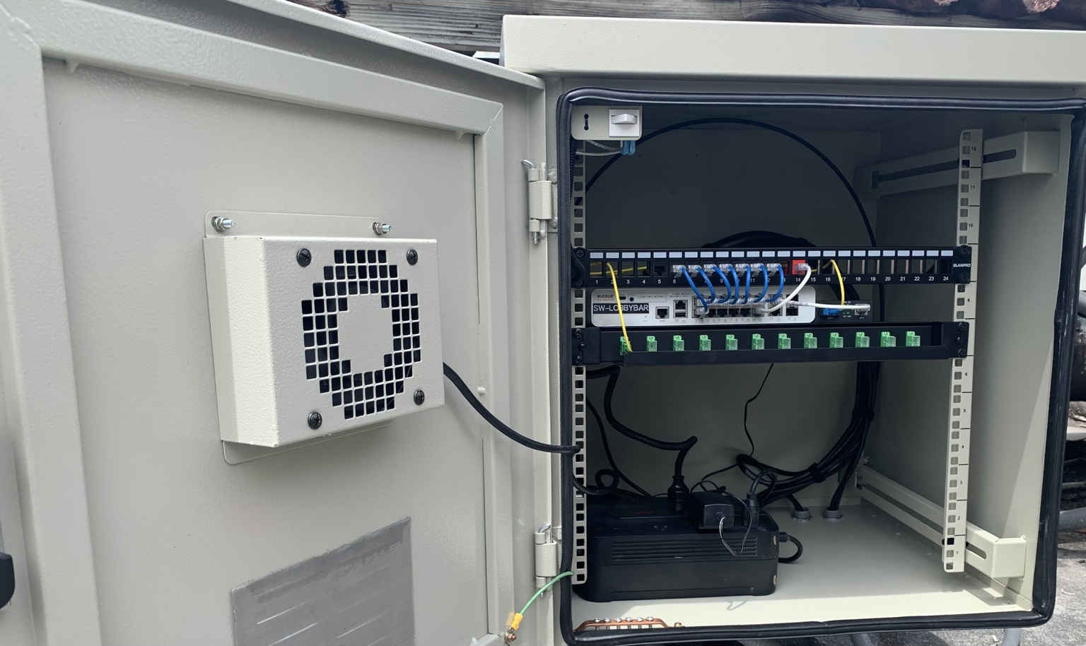 Gabinete de red con patch panel, switch y distribución de fibra óptica