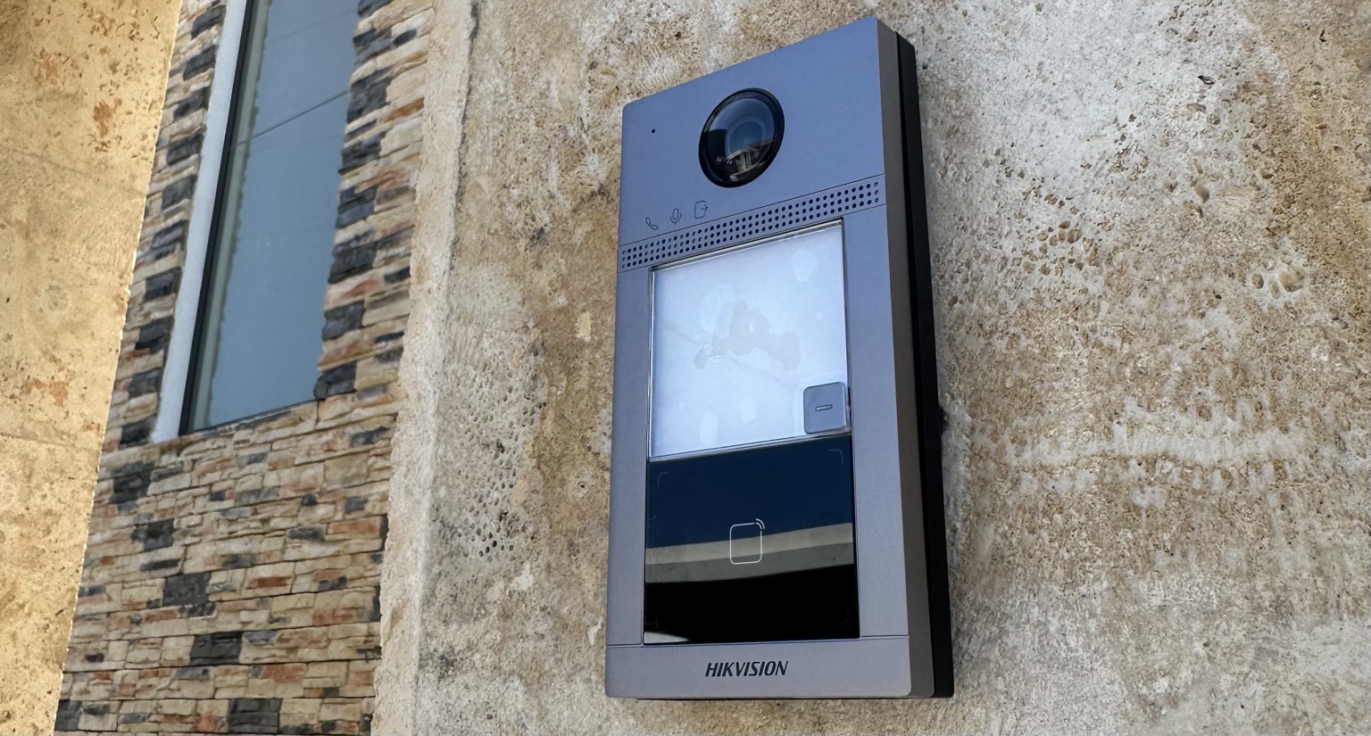 Videoportero Hikvision instalado en una entrada con revestimiento de piedra