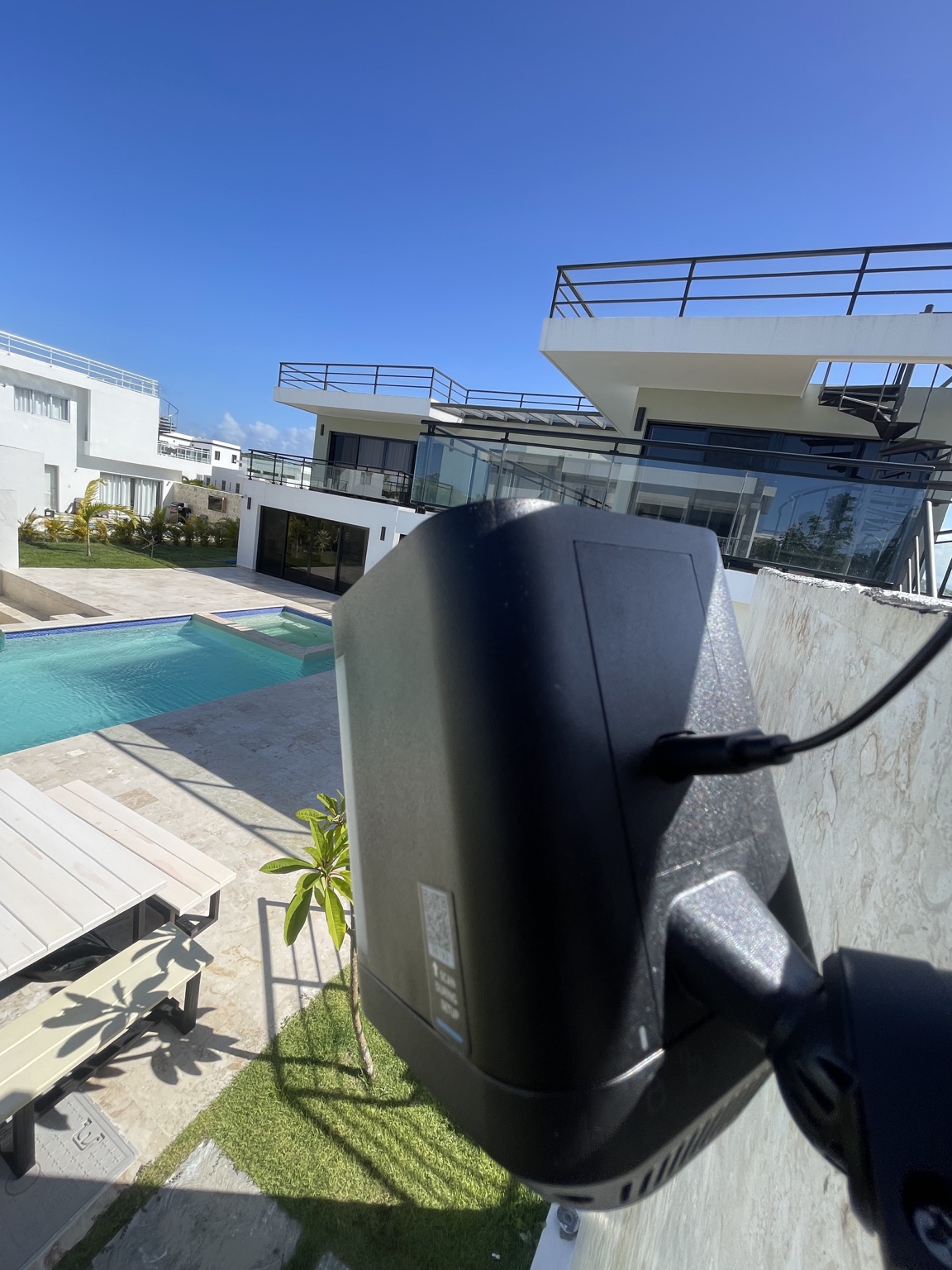 Cámara de seguridad exterior instalada junto al área de piscina de una residencia